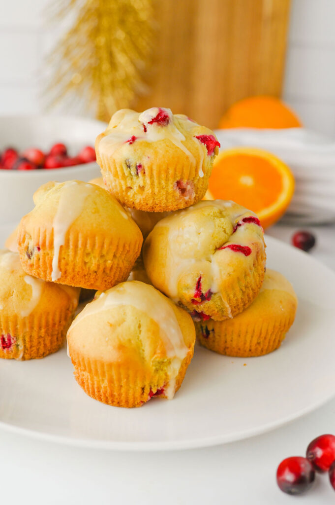cranberry orange muffins stacked on white plate