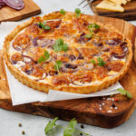 onion tart on cutting board and parchment paper