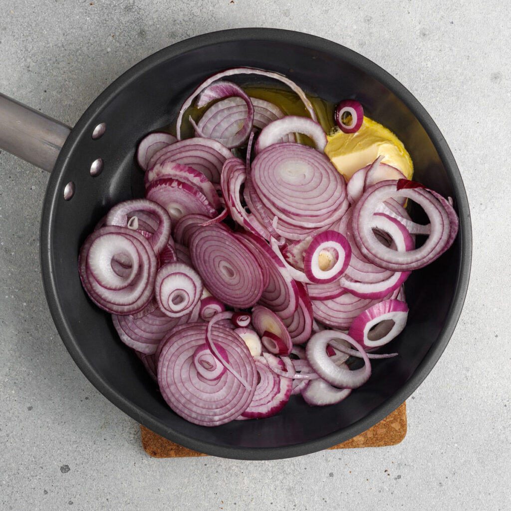 sliced red onions in skillet