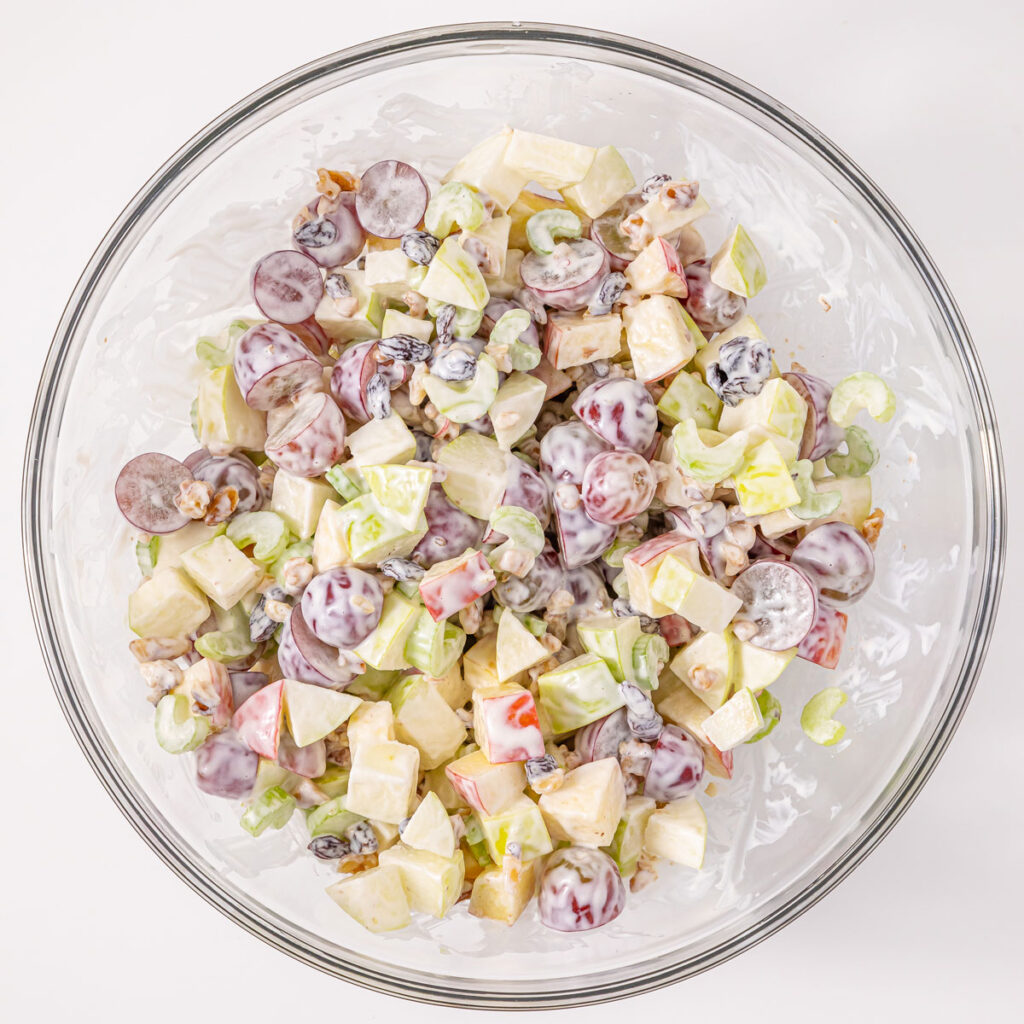waldorf salad and dressing in glass bowl