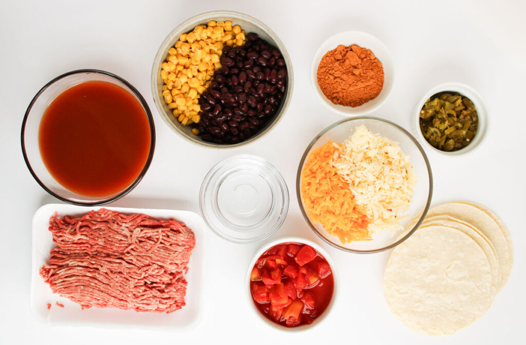 enchilada casserole ingredients in bowls on countertop