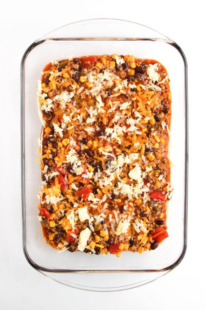 unbaked layers of enchilada casserole