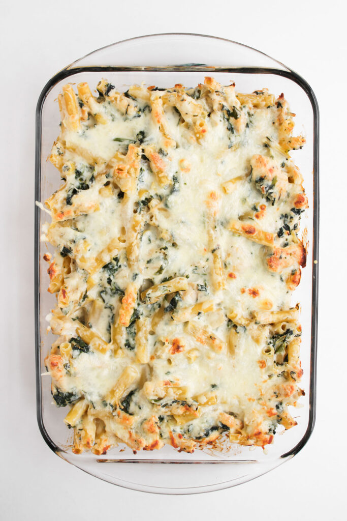 baked spinach Artichoke Chicken Casserole in glass dish
