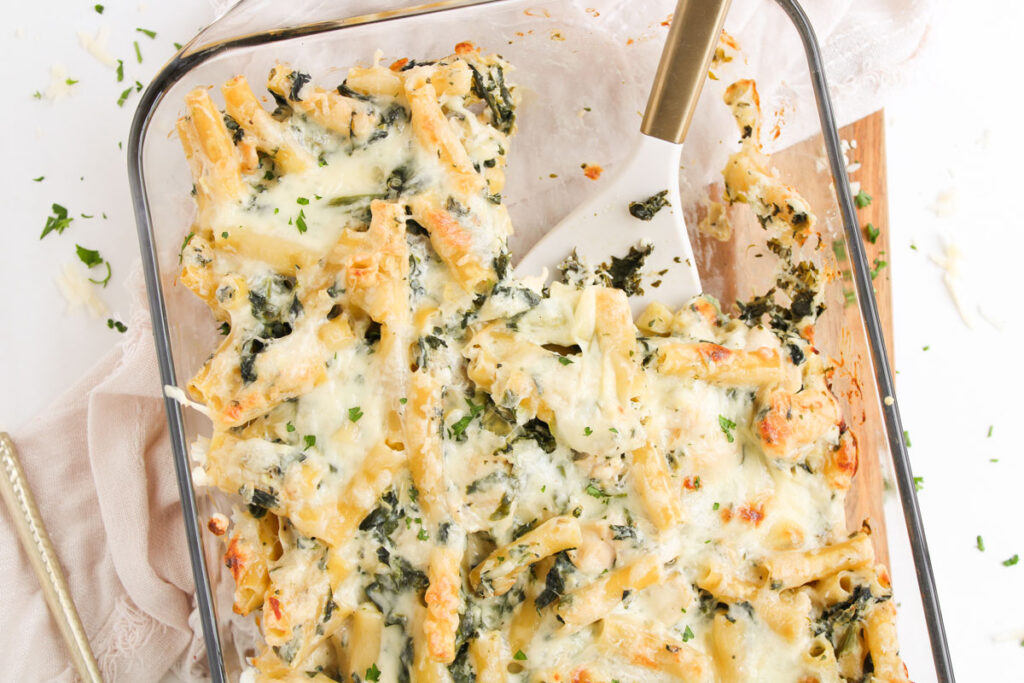 dish with spinach Artichoke Chicken Casserole and one scoop removed