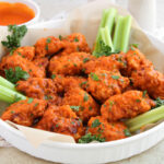 boneless buffalo wings and celery on white plate