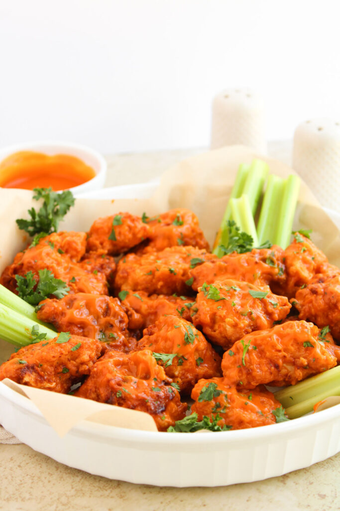 boneless buffalo wings and celery on white plate